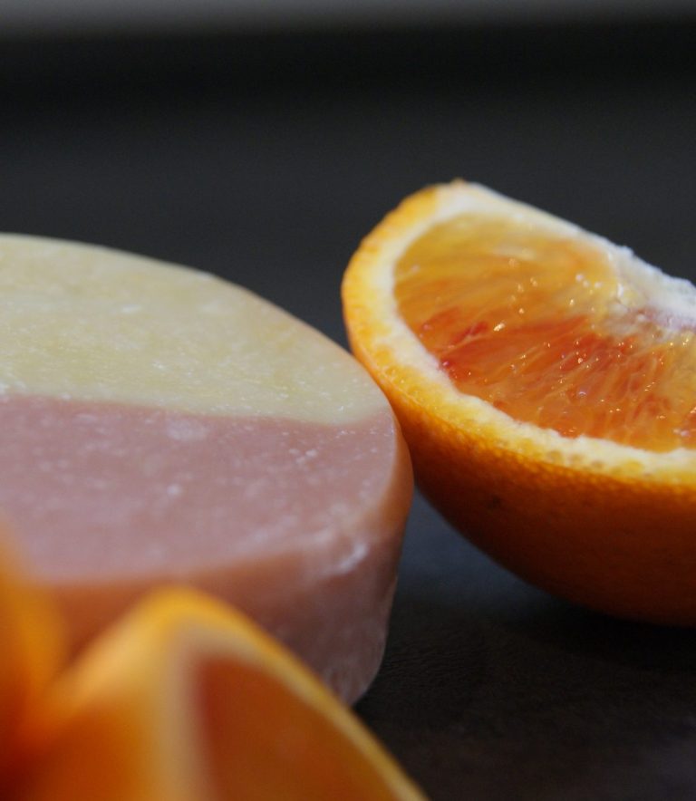 Gelbe Seife mit weißen, geformten Details auf der Oberfläche in einer Holzform.