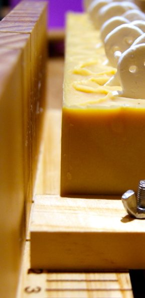 Ein Stück Seife auf einem Holzgestell, mit hellen und gelben Details.