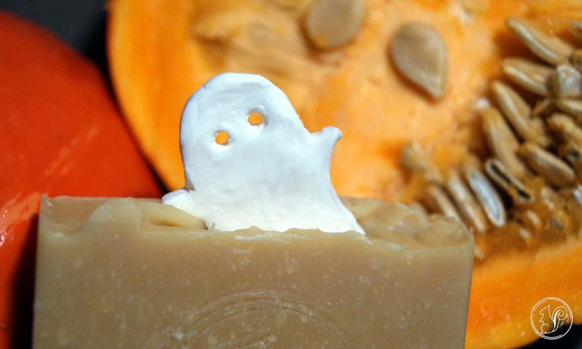 Seife mit einer Geisterfigur aus Sahne, umgeben von Kürbis und Samen.
