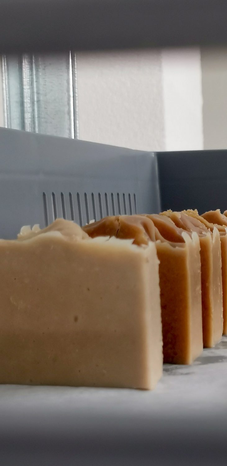 Ein Stück Seife auf einem Holzgestell, mit hellen und gelben Details.